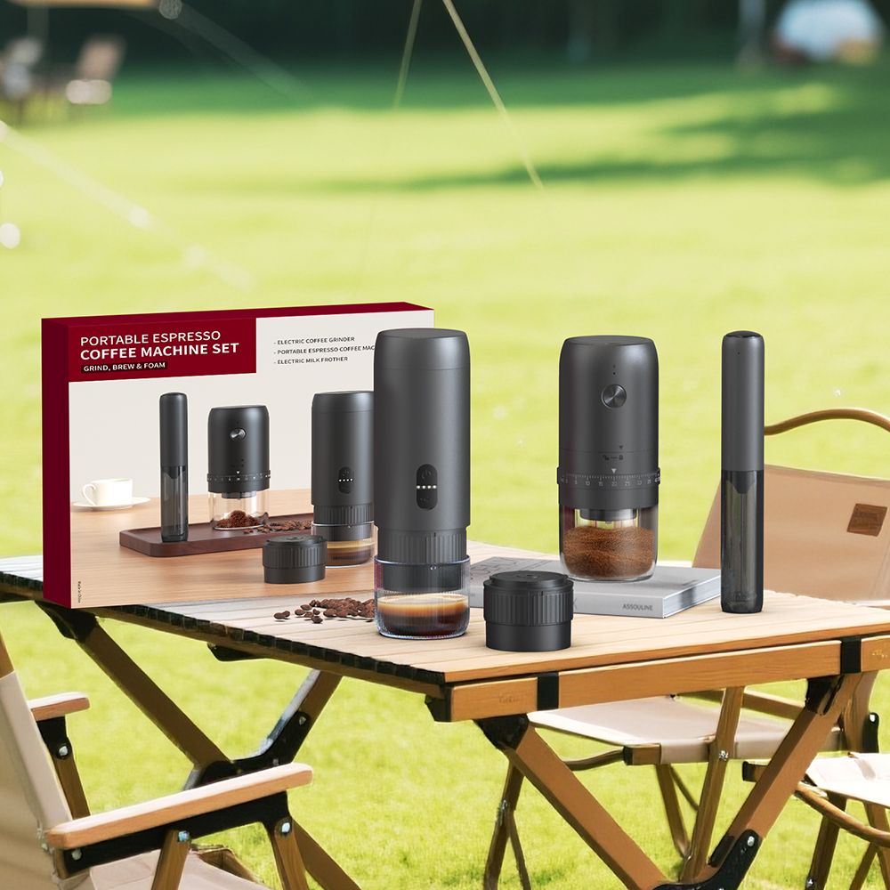 The Ermona portable espresso set on a folding table outdoors, with the espresso maker, grinder and milk frother beside the box.
